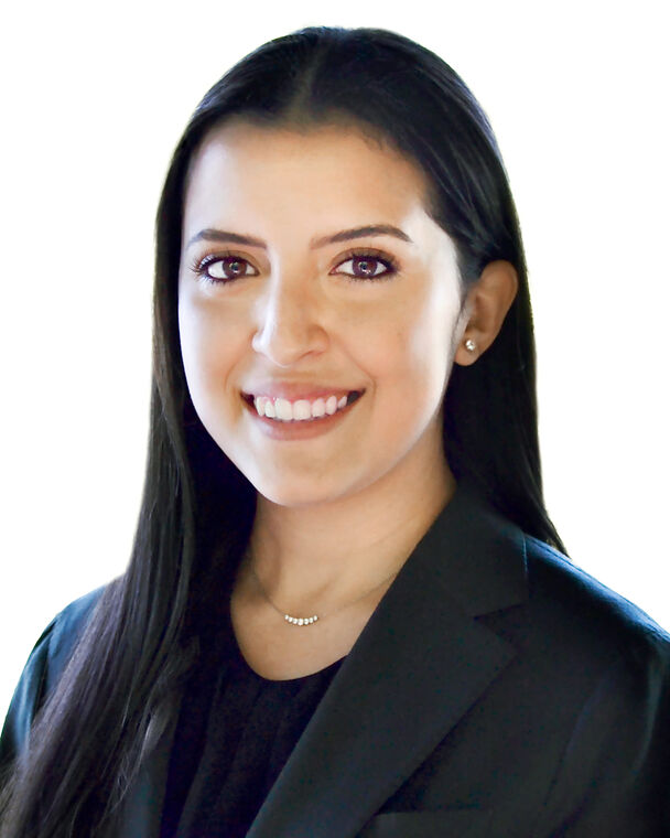 A headshot of Adriana Echeverria Gonzalez who is smiling at the camera and wearing a dark blazer.