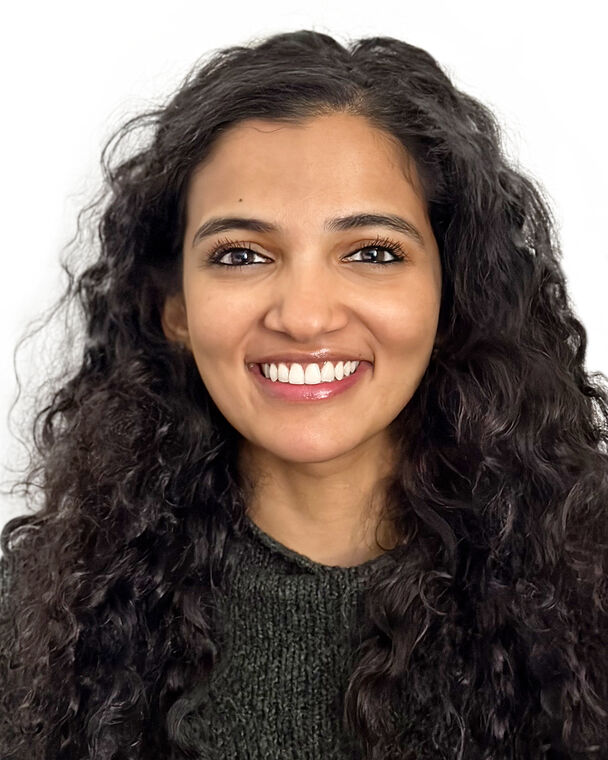 A headshot of Ashri who is smiling at the camera.