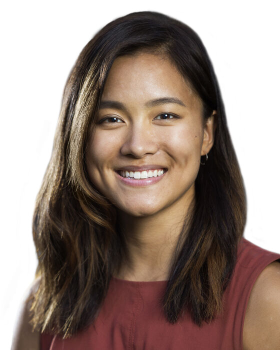 A headshot of Eana Meng who is smiling at the camera and wearing a burnt orange top.