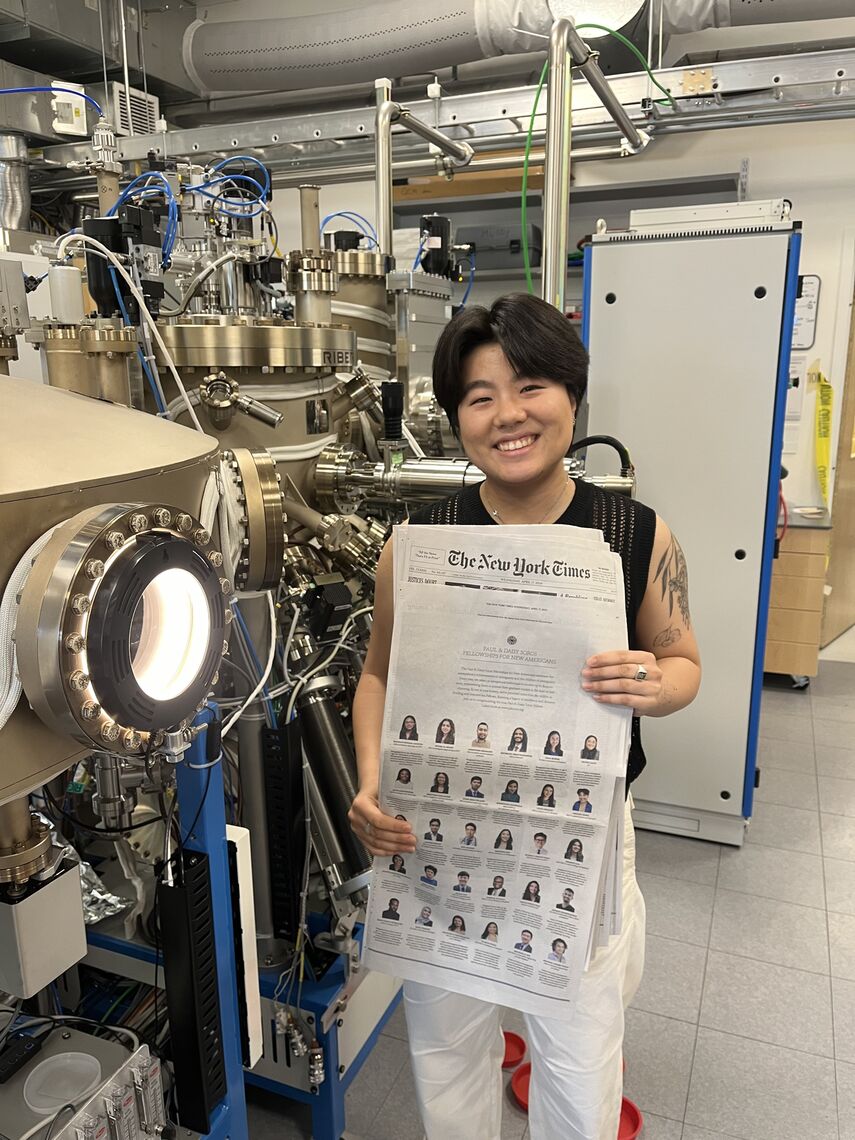 abigail jiang in the mundy group laboratory next to teir molecular beam epitaxy chamber system that they use to synthesize our thin film materials
