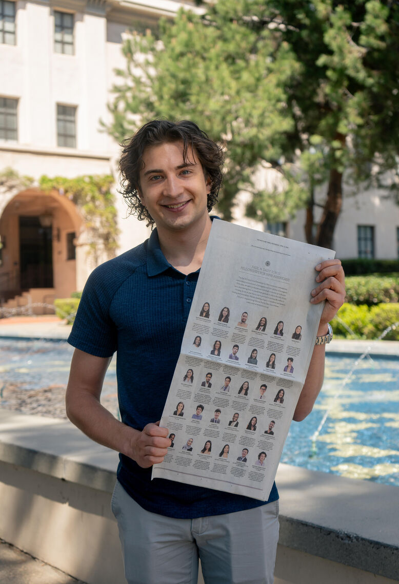 michael yusov standing in sunny california holding the new york times advertisement