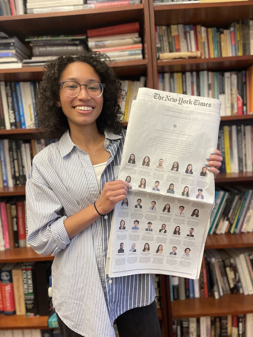 kristine guillaume holding the new york times advertisement at yale where she is a phd student