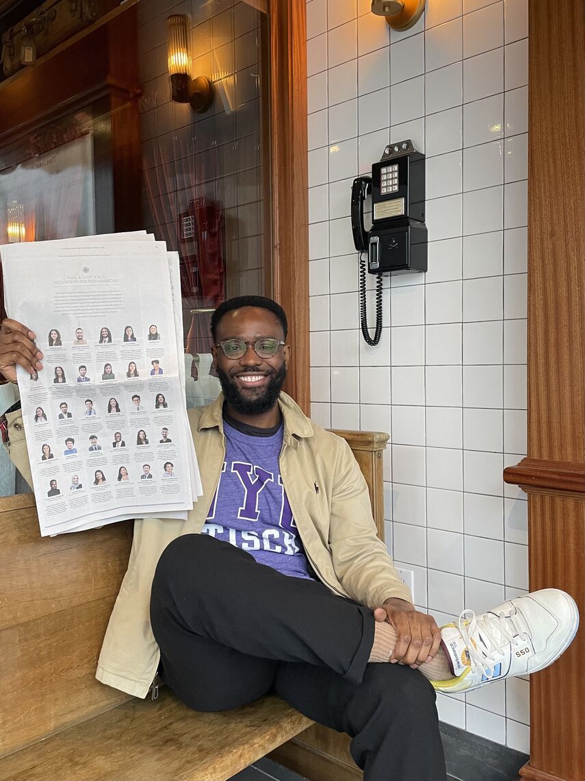 saidu tejan thomas holds the new york times advertisement in a restaurant in new york where he lives