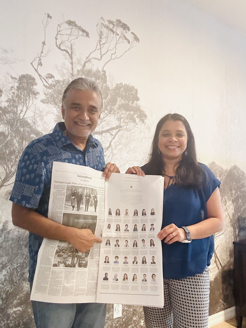 2024 Fellow Malavika Kannan's parents holding the New York Times advertisement and pointing the picture of Malavika.